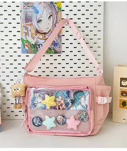 Detailed close-up of pink ita bag with transparent window and decorative plush charms
