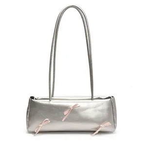 Silver faux leather baguette bag with pink bows and long shoulder straps for women