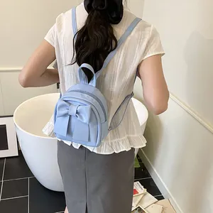 Light blue mini backpack for women featuring a large decorative bow and shiny PU leather