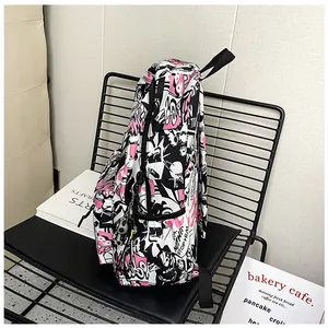 Side view of large capacity canvas backpack with black, white, and pink comic print detail