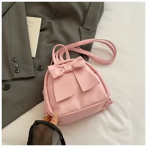 Mini light pink backpack with large leather bow detail and versatile carry straps