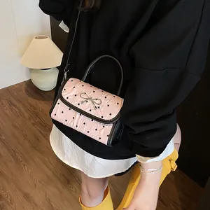 Pink heart-patterned crossbody bag with black trim and silver bow metallic buckle