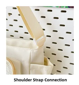 Detail of adjustable strap buckle and side pocket on the cream nylon crossbody bag