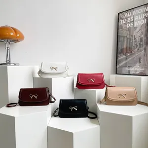 Minimalist leather underarm bags in five colors with gold bow buckles on display