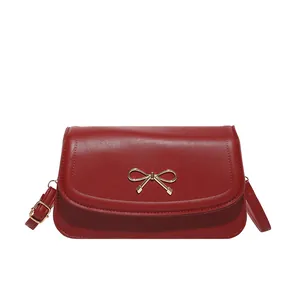 Minimalist dark red crossbody bag with golden butterfly buckle and adjustable strap