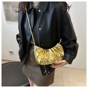 Detailed close-up of metallic gold pleated dumpling bag with elegant chain strap and texture