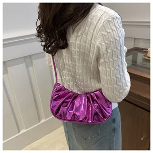 Close-up of metallic purple pleated dumpling bag with shiny mirror finish texture