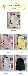 Detail showing five colors of nylon backpacks with cute plush puppy charms on desk