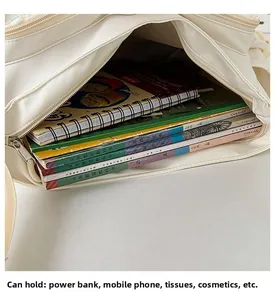 Interior view showing the large capacity of the beige canvas bag filled with books