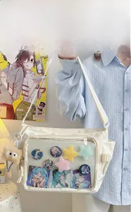 White canvas ita bag with large transparent PVC window displaying anime badges and pins