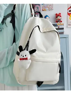 Detail of cream nylon backpack featuring a cute character plush pendant and large pockets