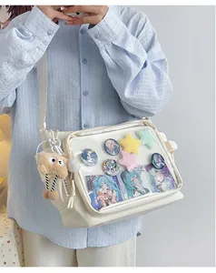 Detailed view of white PU Ita bag with transparent PVC window and plush star decorations