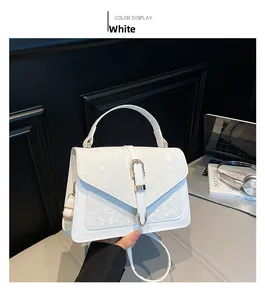 Détail du petit sac blanc en similicuir avec motif serpent et boucle dorée