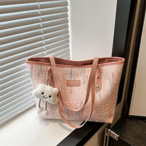 Bolso tote rosa a rayas con textura en relieve y lindo colgante de nube en mesa de madera