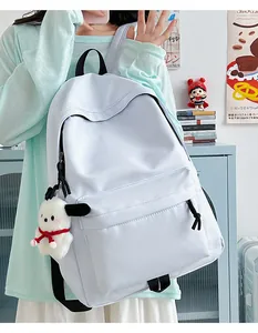 Detail of light blue nylon backpack with plush charm in a cozy student dormitory setting