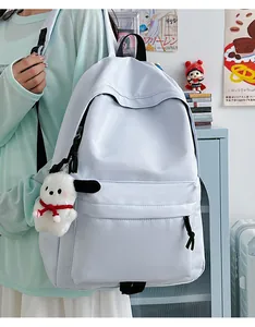 Detail of light blue waterproof nylon backpack with plush charm and zipper pocket