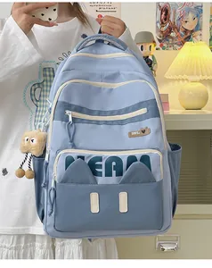 Detail of light blue school backpack with cute cat ears and plush charm on the side