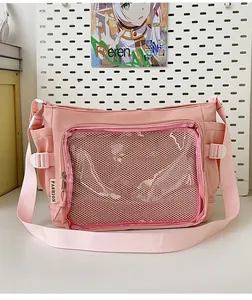 Pink canvas ita bag featuring a clear front window and adjustable shoulder strap