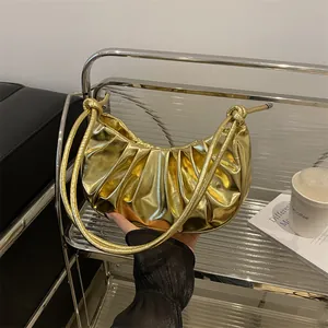 Glossy metallic gold pleated crescent handbag with sleek leather shoulder strap