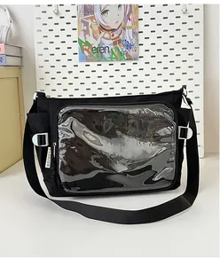 Detail of black canvas ita bag featuring a clear PVC window and side pocket with fashion tag