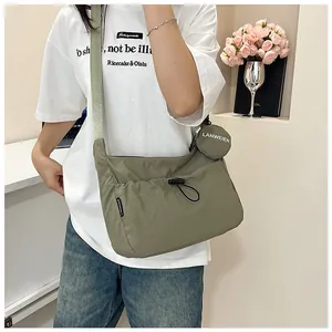 Détail du sac bandoulière en nylon vert olive avec poche à cordon et petit porte-monnaie