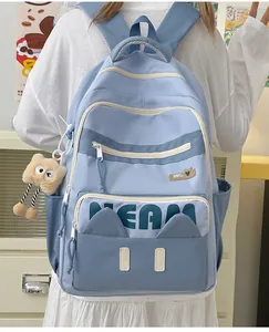 Detailed back view of a light blue student backpack with cute cat ears and bear keychain