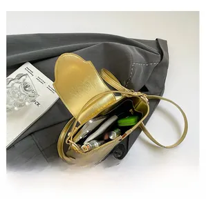 Vista superior de bolso bandolera dorado trenzado que muestra amplio almacenamiento interno