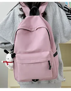Pink waterproof nylon backpack with a cute plush dog pendant from the back view