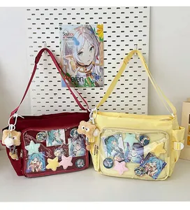 Detail of red and yellow Ita bags with clear PVC windows and anime accessory charms