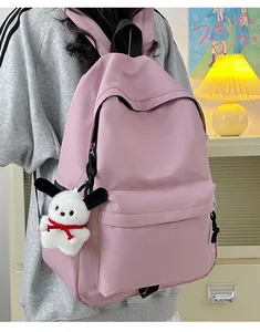 Close-up of a pink nylon backpack featuring a cute white puppy pendant and side pocket detail