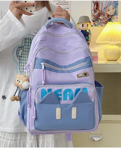 Close-up of purple and blue school backpack with cute cat ear pockets and plush pendant
