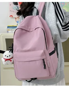 Pink nylon backpack for students featuring a cute puppy plush charm and side straps