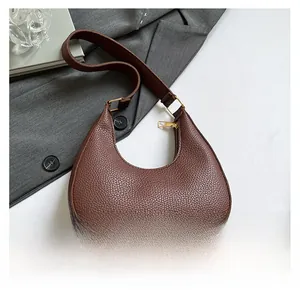 Detail of dark brown pebble leather hobo bag with gold zipper and textured surface