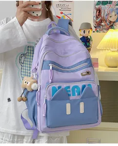 Detailed side view of lavender and blue backpack with cute cat ear pockets and plush charm