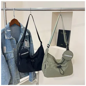 Détail du sac bandoulière en nylon avec cordon de serrage et petit porte-monnaie rond