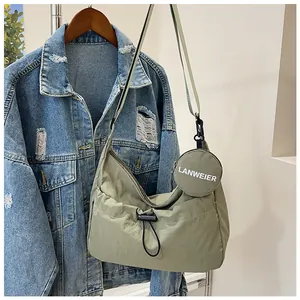 Détail du sac bandoulière nylon vert clair avec petit porte-monnaie rond et cordon
