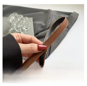 Detail of the durable brown PU leather shoulder strap with reinforced double stitching