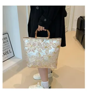 Detail showing the bamboo handle and floral jacquard texture on this vintage tote bag