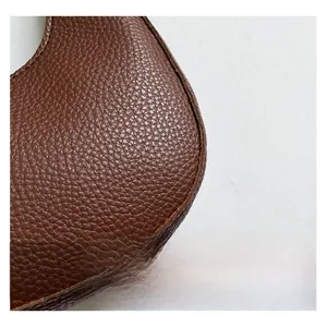 Detail of caramel brown crescent bag showing high-quality lychee grain leather texture