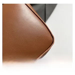 Close-up of premium brown leather texture and precise stitching on the crescent bag