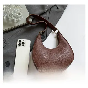 Brown litchi leather crescent bag with wide shoulder strap and gold buckle detail