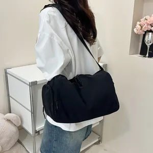 Gros plan du sac de sport en nylon noir avec compartiment latéral zippé et bandoulière