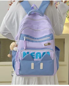 Detail of lavender school backpack with blue contrast pockets and cute bear charm pendant