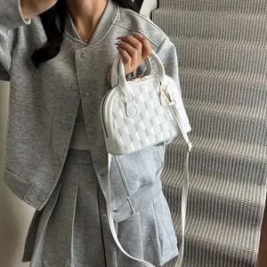 Close-up of woven texture and gold hardware on white shell bag with top handles