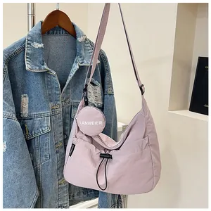 Détail du sac croissant lilas montrant le cordon de serrage et le porte-monnaie rond