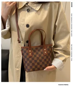 Detail of vintage checkered bucket bag with gold studs and adjustable leather strap