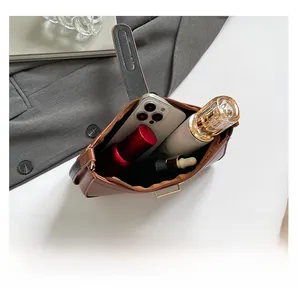 Interior view of brown leather crescent bag showing ample space for phone and perfume