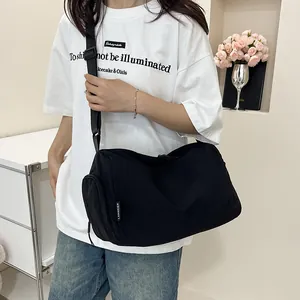 Détail d'un sac bandoulière en nylon noir avec poche zippée et sangle ajustable