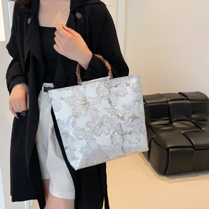 Floral jacquard tote bag with natural bamboo handles in a modern Chinese retro style