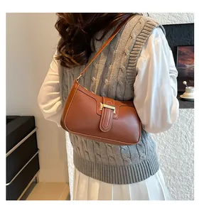 Caramel brown vintage crescent shoulder bag with matte leather and metal buckle detail